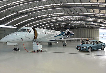 Embraer in hangar with customers arriving in luxury car